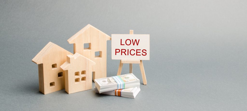 Wooden houses and a poster with the words Low Prices