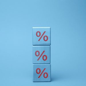 Wooden blocks with percent on a blue background. The concept of reducing or increasing prices